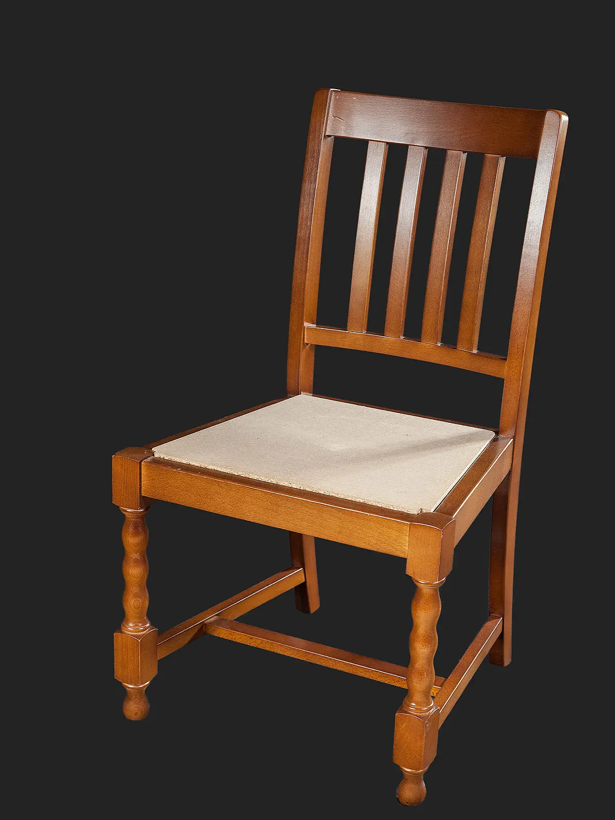 A classic wooden dining chair featuring a slatted back design and a beige cushion seat, set against a black background.