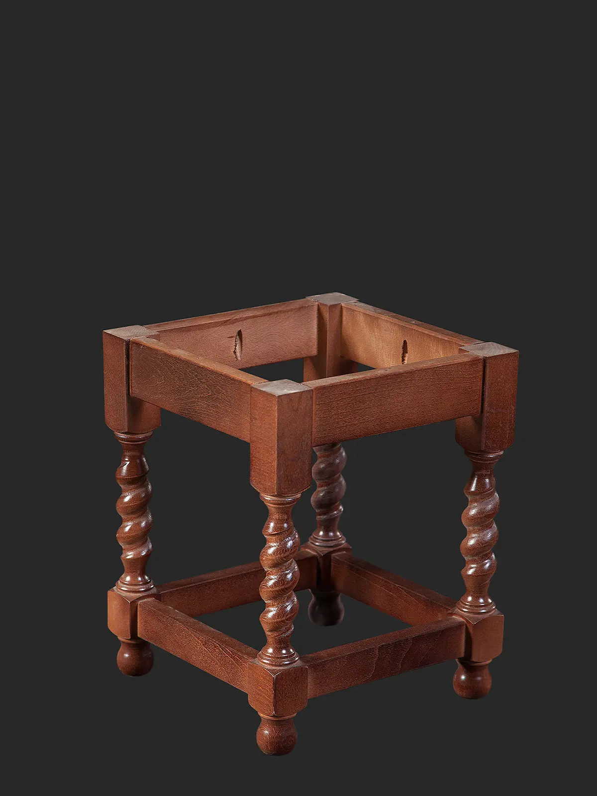 A wooden table stand featuring four spiraled legs and a square top design, showcasing classic craftsmanship.