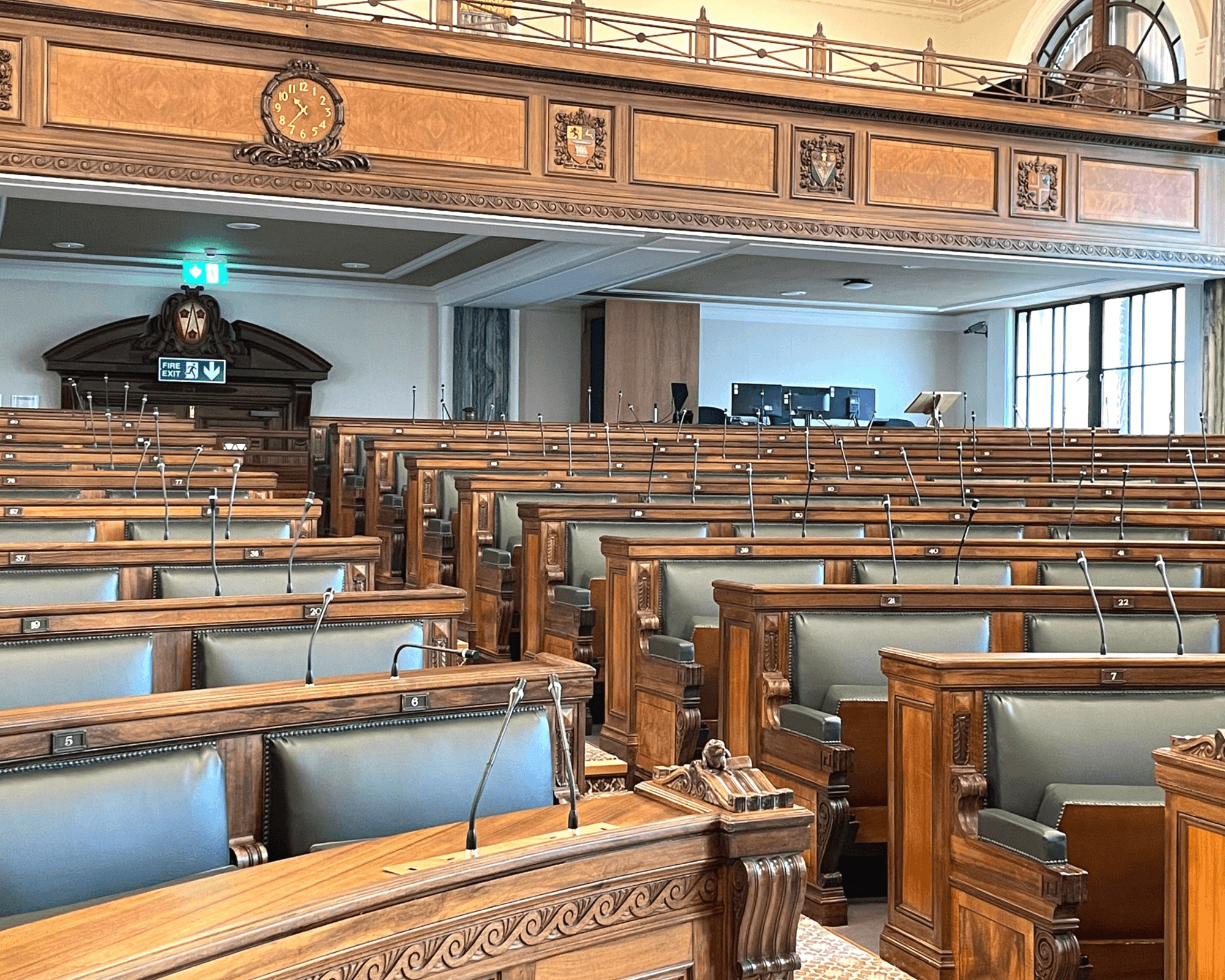 View of empty legislative chamber with wooden seating and architecture