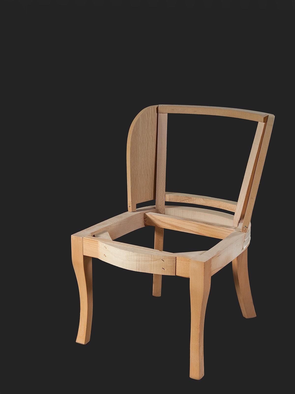 Unfinished Wooden Chair Frame An incomplete wooden chair frame highlighting the seat and backrest structure against a black background.