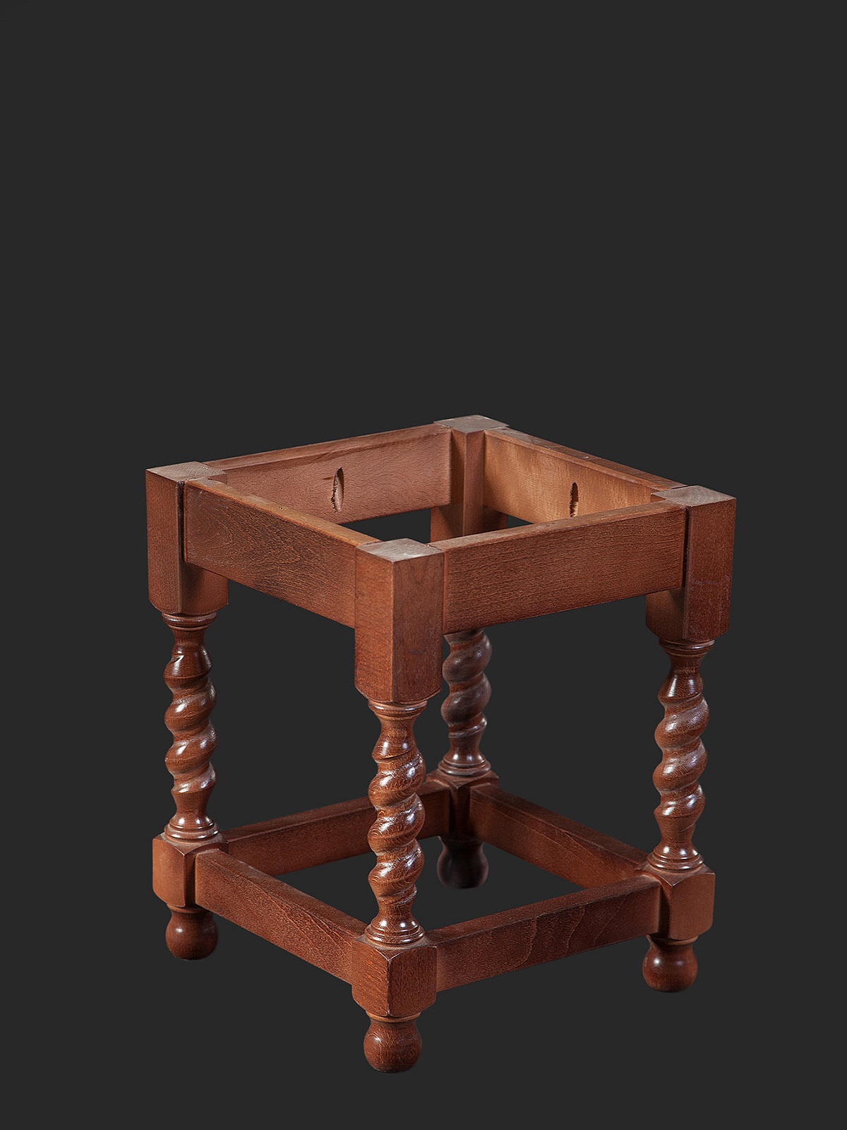 A wooden table stand featuring four spiraled legs and a square top design, showcasing classic craftsmanship.